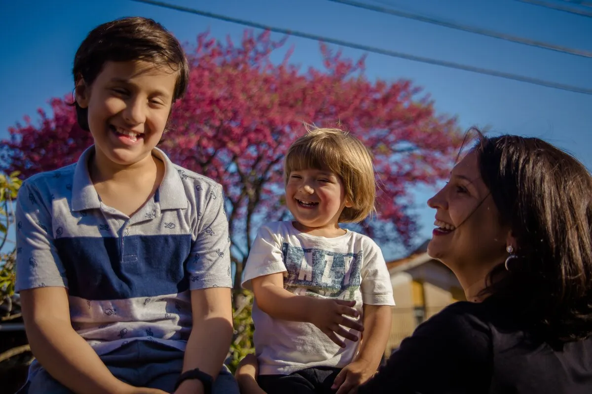 Amábile Marchi com seus dois filhos autistas em momento de carinho e acolhimento